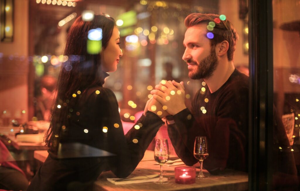 Couple holding hands and looking at each other at the restaurant